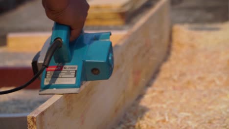 Working-carpenter-to-smoothen-the-plank-using-planer-machine