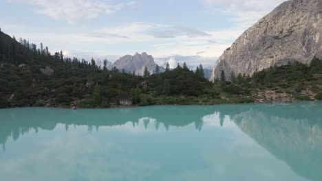 Lake-Sorapis-was-filmed-with-a-drone-during-sunrise-with-mountains-in-the-background-in-the-Dolomites,-Italian-alps