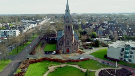 Old-dutch-church-called-Sint-Willibrordus-church-zooming-out-fast-with-a-drone