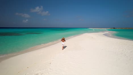 Aerial-turn-around-woman-walk-on-white-sand-beach-lonely-island-tropical-sunset