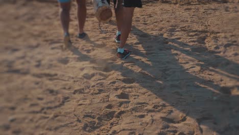 Athletes-By-the-beach-carrying-wooden-bar-and-sandbags---Slow-Motion
