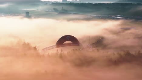 Aerial-foggy-view-during-golden-hour-of-metal-construction-with-company-logo