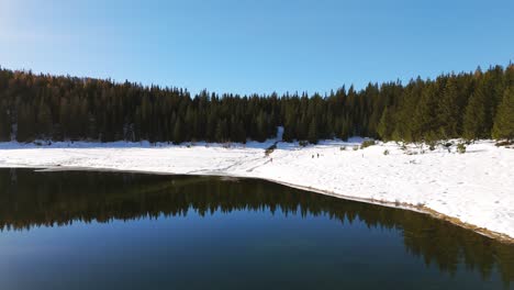 Snowy-shoreline-of-Lago-Palù-on-sunny-day,-Valmalenco,-Italy-alpine-winter-landscape