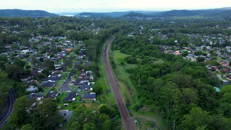 Drone-aerial-scenery-train-line-railroad-track-commute-city-transport-bushland-suburban-metropolitan-Niagara-Park-Narara-NSW-Central-Coast-Australia-4K
