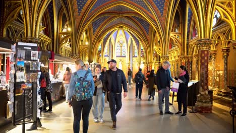People-walking-through-the-lower-chapel-of-La-Sainte-Chapelle-Church-in-Paris,-France---Handheld