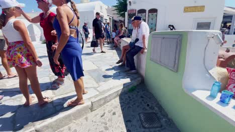 Oia-Santorini-Greece-Island-Travel-Tourist-Immersive-Walk,-Europe,-4K-|-Greek,-Aegean,-Sea,-Cliffside,-Ocean,-City,-Vacation,-Shopping,-White,-Marble,-Crowd,-Flowers,-Traveler,-People,-Feet,-Cluster