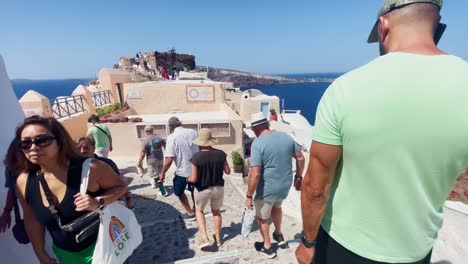 Oia-Santorini-Greece-Island-Travel-Tourist-Immersive-Walk,-Europe,-4K-|-Greek,-Aegean,-Sea,-Cliffside,-Ocean,-City,-Vacation,-Shopping,-White,-Marble,-Crowd,-Flowers,-Traveler,-People,-Stairs,-Hill