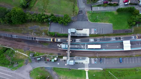 Drone-aerial-landscape-shot-of-city-rail-train-on-railway-line-platform-railroad-Niagara-Park-Lisarow-Ourimbah-station-Central-Coast-transport-Australia-4K