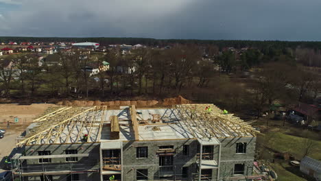 Workers-at-an-modern-condo-construction-site,-sunny-day-in-Latvia---Aerial-view