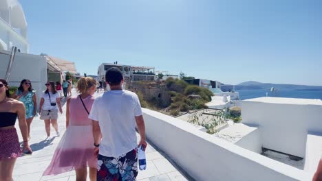 Oia-Santorini-Greece-Island-Travel-Tourist-Immersive-Walk,-Europe,-4K-|-Greek,-Aegean,-Sea,-Cliffside,-Ocean,-City,-Vacation,-Shopping,-White,-Marble,-Crowd,-Flowers,-Traveler,-People,-Couple,-Ocean