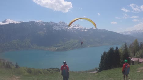 Touristen-Beim-Gleitschirmfliegen-In-Den-Schweizer-Alpen-Mit-Blick-Auf-Eine-Wunderschöne-Aussicht-Auf-Die-Berge---Weitwinkelaufnahme