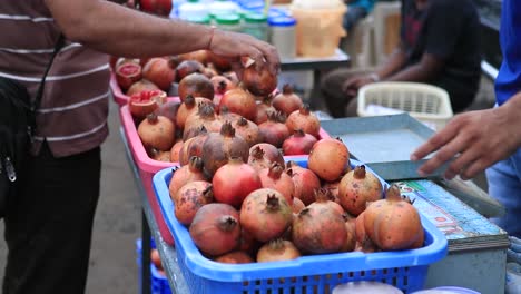 Frauenhand-Wählt-Den-Besten-Granatapfel-In-Lokalen-Geschäften-Aus,-Frischobstmarkt-In-Indien,-Granatapfel-Nahaufnahme