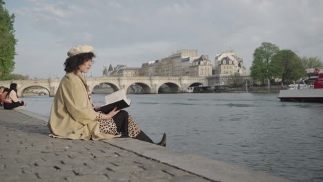 Stylish-Beautiful-Women-Reading-Book-Along-The-Seine’s-River-Bank