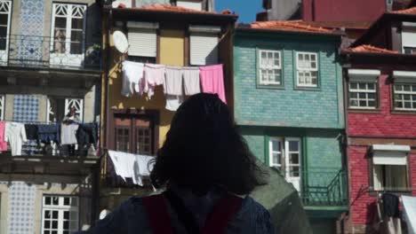 Medium-close-up-shot,-woman-taking-pictures-of-the-Riberia-Square-in-Porto,-Woman-Standing-on-her-balcony