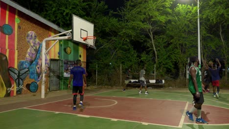 Schwarze-Basketballsportler-Spielen-Nachts-Gemeinsam-Auf-Basketballplätzen-Im-Freien-Eine-Erfolgreiche-Angriffsaktion