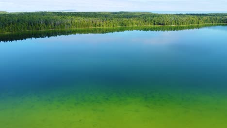 Aerial-Dolly-in-Shot-Beautiful-Smooth-Green-Waters-of-a-Lake-Huron-Bruce-Peninsula,-Georgian-Bay