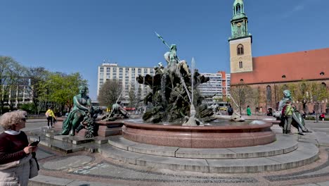 Kaukasische-Frauen-Bleiben-Stehen,-Um-Den-Neptunbrunnen-In-Berlin,-Deutschland,-Zu-Bewundern