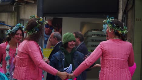 Halbnahe-Aufnahme,-Frauen-In-Rosafarbenem-Blumenkleid-Tanzen-Mit-Einigen-Touristen-Auf-Der-Straße,-Leute-Im-Hintergrund-Schauen-Zu
