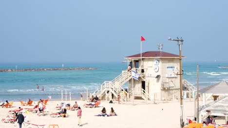 Torre-De-Salvavidas-De-La-Playa-De-Arena-Mediterránea-De-Tel-Aviv-Y-Playa-Repleta-De-Gente