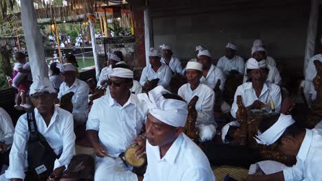 Senior-Musicians-Play-Gamelan-Angklung-Music-in-Balinese-Hindu-Temple-Ceremony-wearing-White-Traditional-Clothes