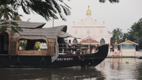 Blick-Auf-Den-Alleppey-Curch-Tempel-Und-Ein-Vorbeifahrendes-Hausboot,-Backwaters-Von-Kerala,-Indien