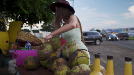 Woman-model-choosing-coconuts-in-road-side-stand-in-Jalisco,-Mexico---Close-up-shot