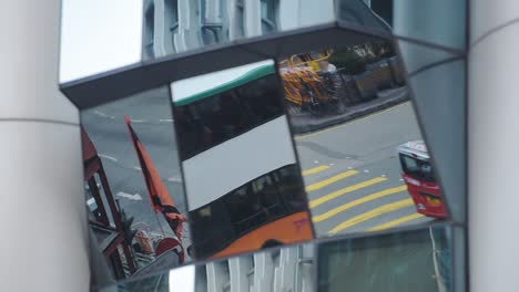 Gebäudespiegelung-Von-Transportfahrzeugen-Und-Menschen,-Die-An-Der-Fußgängerzone-In-Hongkong-Vorbeifahren-–-Aufnahme-Aus-Der-Tiefwinkelansicht
