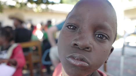 Nahaufnahme-Eines-Jungen-Afrikanischen-Kindes,-Das-Vor-Freude-In-Einer-Gruppe-Von-Freunden-Lächelt