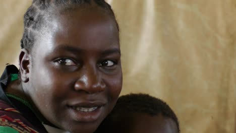 Afrikanisches-Kind-Und-Mutter-Halten-Baby,-Traditionelle-Frisur-Auf-Schlichtem-Hintergrund