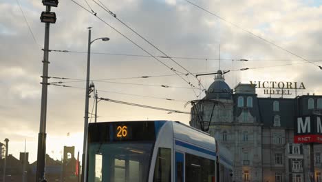 Slow-motion-busy-street-scene-in-Amsterdam-with-tram,-pedestrians-at-dusk