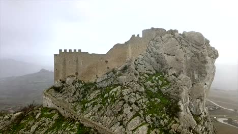 Drone-Shote-flying-down-tracking-from-the-top-to-the-bottom-of-the-Mussomeli-Castle,-in-the-town-where-houses-are-sold-at-1-Euro