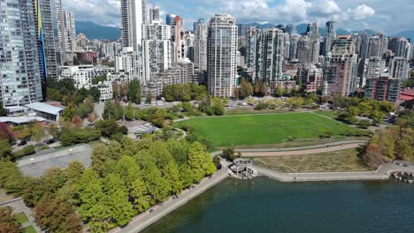 Drone-shot-of-a-park-by-downtown-Vancouver-buildings