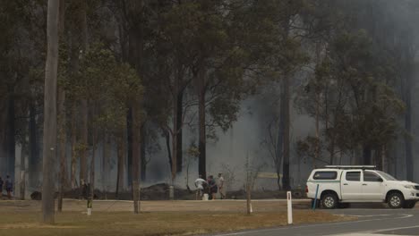 The-locals-watching-on-as-emergency-services-respond-to-a-rural-fire,-in-Darawank-Tuncurry-Forster-area