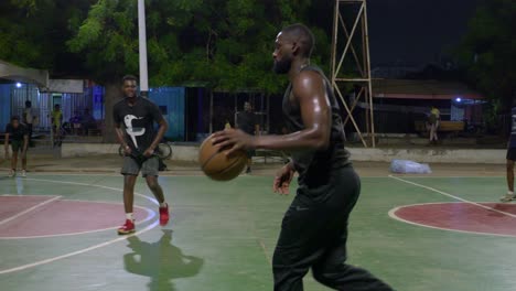slow-motion-following-a-black-male-players-in-basketball-performing-a-attack-offensive-action-during-training-in-outdoor-court-at-night