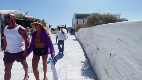 Oia-Santorini-Greece-Island-Travel-Tourist-Immersive-Walk,-Europe,-4K-|-Greek,-Aegean,-Sea,-Cliffside,-Ocean,-City,-Vacation,-Shopping,-White,-Marble,-Crowd,-Flowers,-Traveler,-People,-Wall,-Pathway