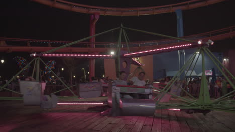 Night-time-slow-mo-shot-of-people-riding-amusement-park-ride-in-Pacific-Park-located-on-the-Santa-Monica-Pier