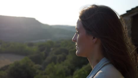 Slowmotion-close-up-of-a-beautiful-woman-looking-at-the-forestal-landscape-during-sunset