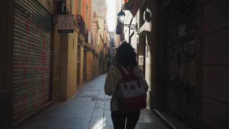 Toma-En-Movimiento-Medio,-Mujer-Sosteniendo-Una-Cámara-Mientras-Caminaba-Por-Las-Calles-De-Barcelona,-España,-Día-Soleado-En-El-Fondo