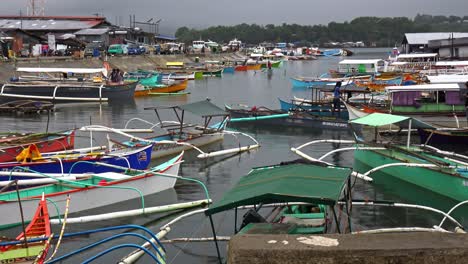 Small-boats-hustle-for-a-space-in-the-harbor-of-Surigao-City,-Philippines