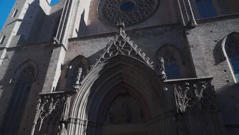 Nach-Oben-Und-Unten-Neigende-Aufnahme,-Malerische-Außenansicht-Einer-Kirche-In-Barcelona,-Spanien,-Vorbeifliegender-Vogel-Am-Blauen-Himmel