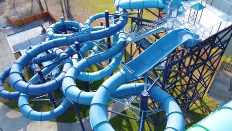 A-complex-blue-water-slide-structure-at-an-outdoor-park-surrounded-by-grass