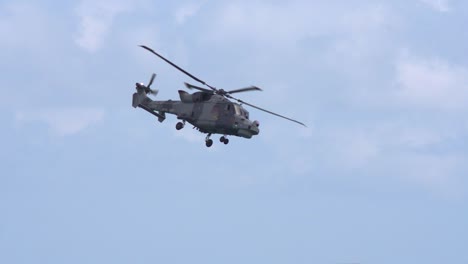 Close-up-tracking-shot-of-a-Navy-lynx-helicopter-and-clear-view-of-the-rotor-blades-midair-at-Bournemouth,-England