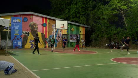 Slow-motion-of-black-african-team-of-athletes-play-outdoor-basketball-in-africa-at-night