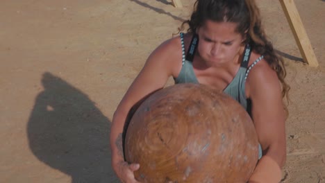 A-Strong-Female-Athlete-lift-Giant-rock-spheres-up-and-throw-it-away-heavily---Slow-Motion