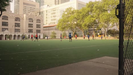 Pov-forward-shot-showing-group-of-teenager-playing-soccer-on-field-in-central-New-York---Slow-motion