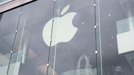 Customers-are-seen-at-the-American-technology-brand,-Apple,-official-store-and-company-logo-in-Hong-Kong