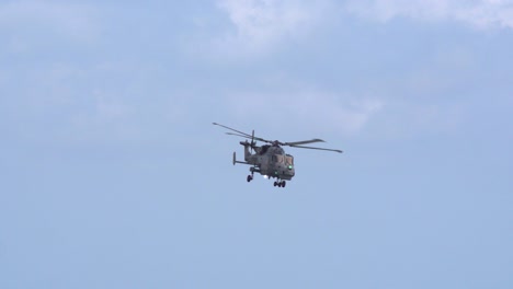 Ein-Militärhubschrauber-Der-Marine-Lynx-Schwebt-In-Superzeitlupe-Am-Klaren-Himmel,-Bournemouth,-England