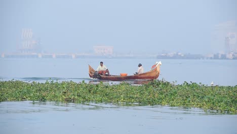 Local-Fishermen-On-Traditional-Wooden-Fishing-Boat-Travelling-In-Fort-Kochi-In-Kerala,-India