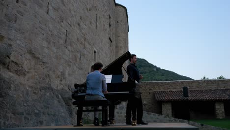 Shot-of-a-pianist-and-singer-performing-on-castle-ruins-in-France