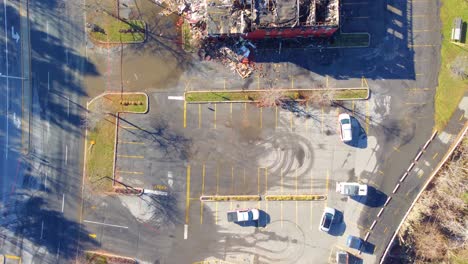 Drone-Following-Street-Sweeper-Circling-Mess-Outside-of-Demolished-Building